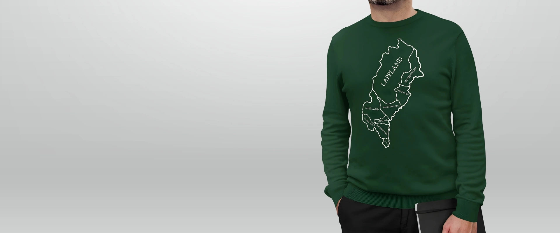 Grön Norrländsk streetwear sweatshirt Man i grön Norrländsk streetwear sweatshirt med vit karta över Norrland och Lappland – en hyllning till Sveriges norra landskap från Heart of North.