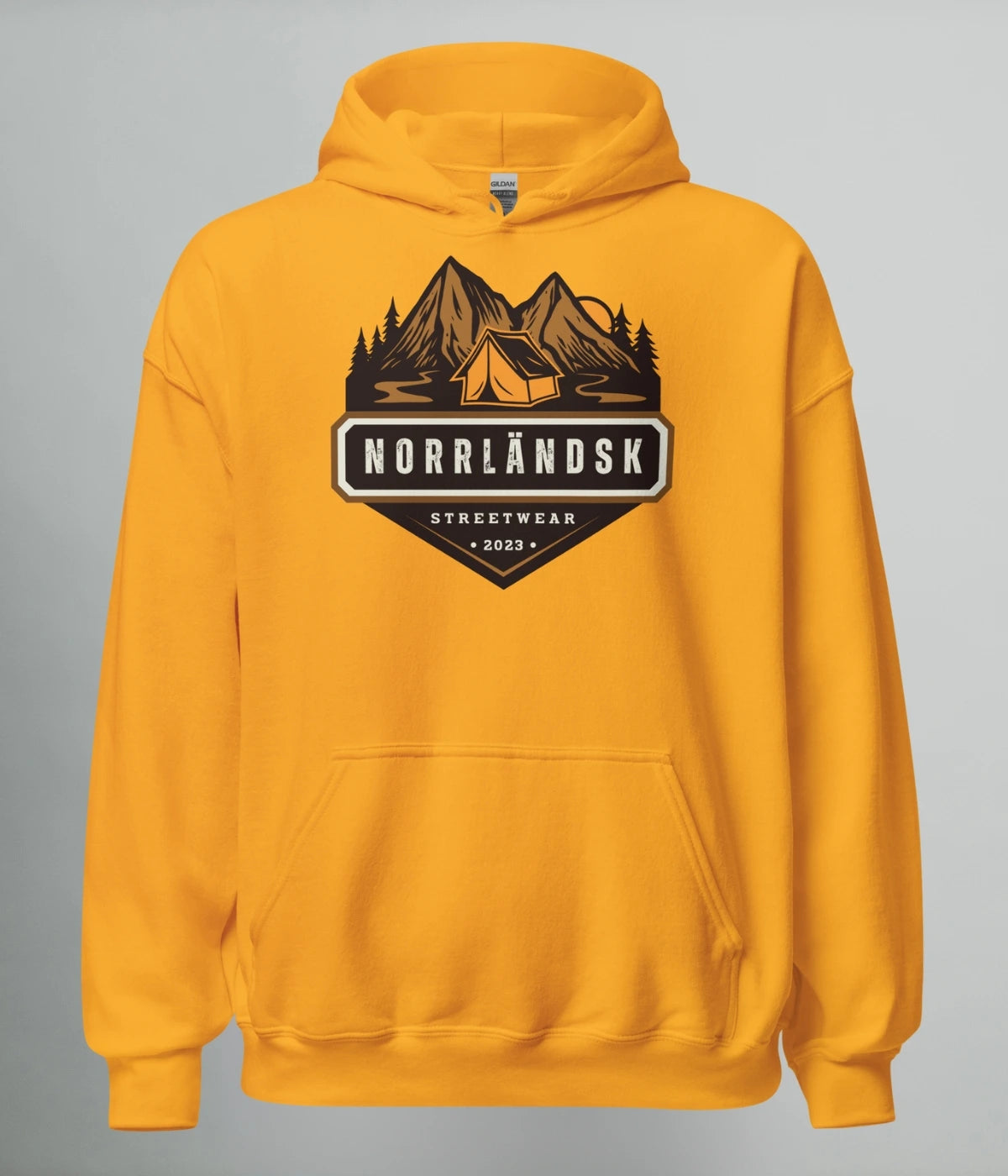 Gul hoodie med illustration av fjäll, skog och stuga – Norrländsk streetwear med texten "Norrländsk Stugliv Streetwear 2023" från Heart of North.