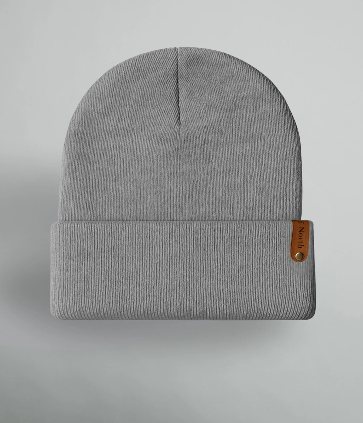 Grå unisexmössa med uppvik och brun läderlapp med texten ”Heart of North” från Heart of North. Enkel och stilren vintermössa i norrländsk design.