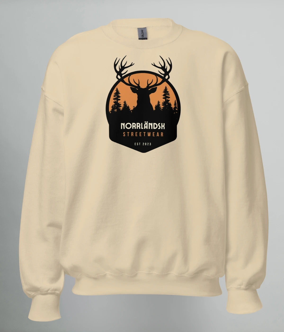 Beige unisex sweatshirt med silhuettmotiv av en hjort mot solnedgång och texten "Norrländsk Streetwear – Est 2023", tryckt på bröstet.