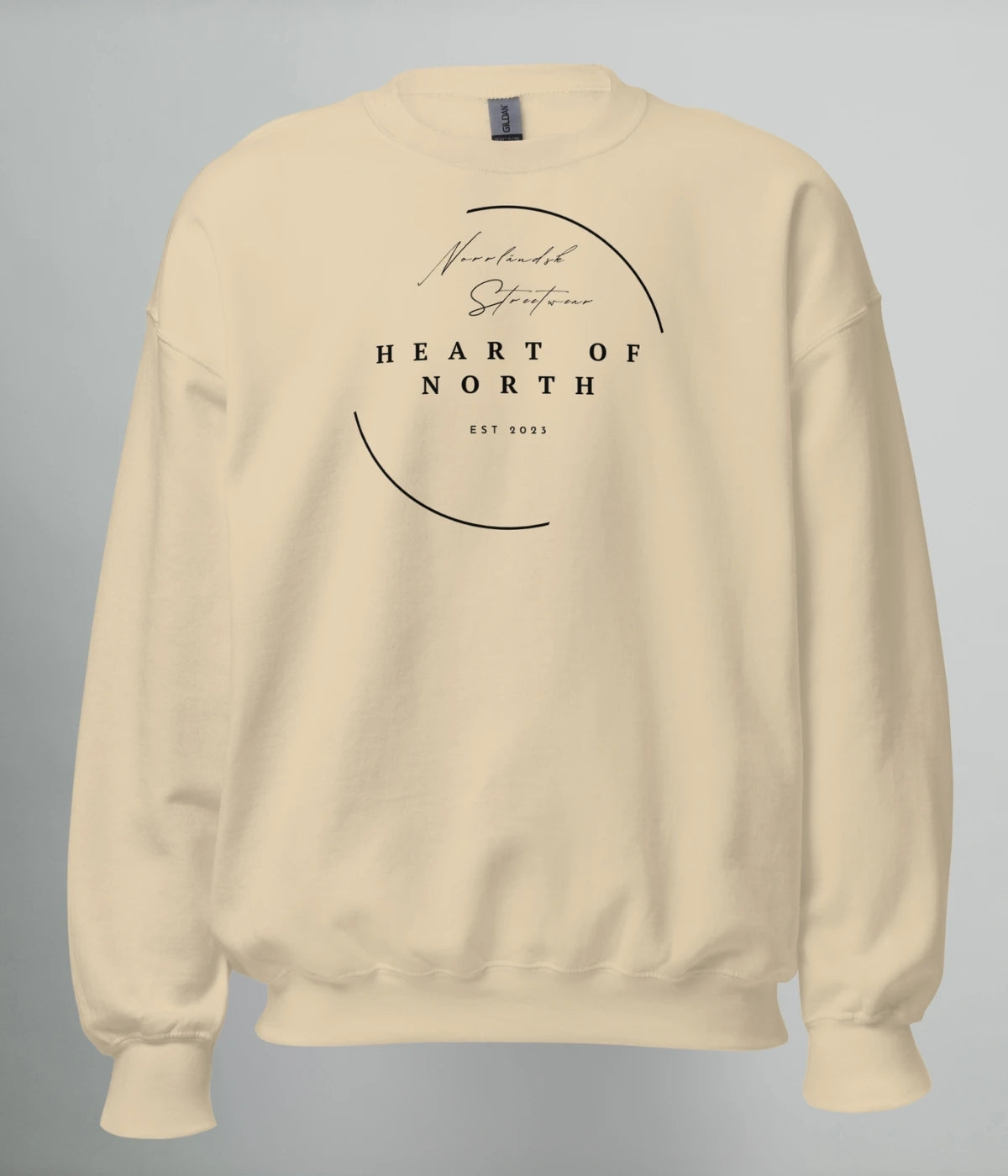 Beige unisex sweatshirt med vit minimalistisk design och texten “Norrländsk Streetwear – Heart of North – EST 2023” tryckt framtill.