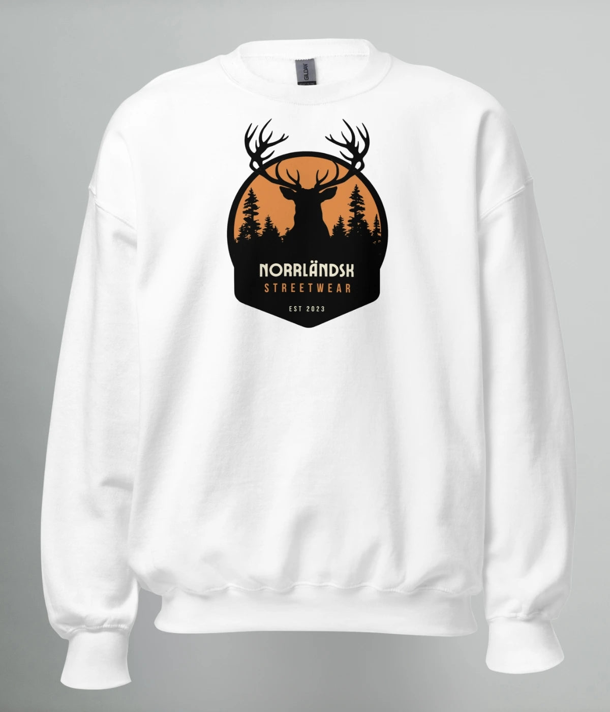Vit unisex sweatshirt med silhuettmotiv av en hjort mot solnedgång och texten "Norrländsk Streetwear – Est 2023", tryckt på bröstet.