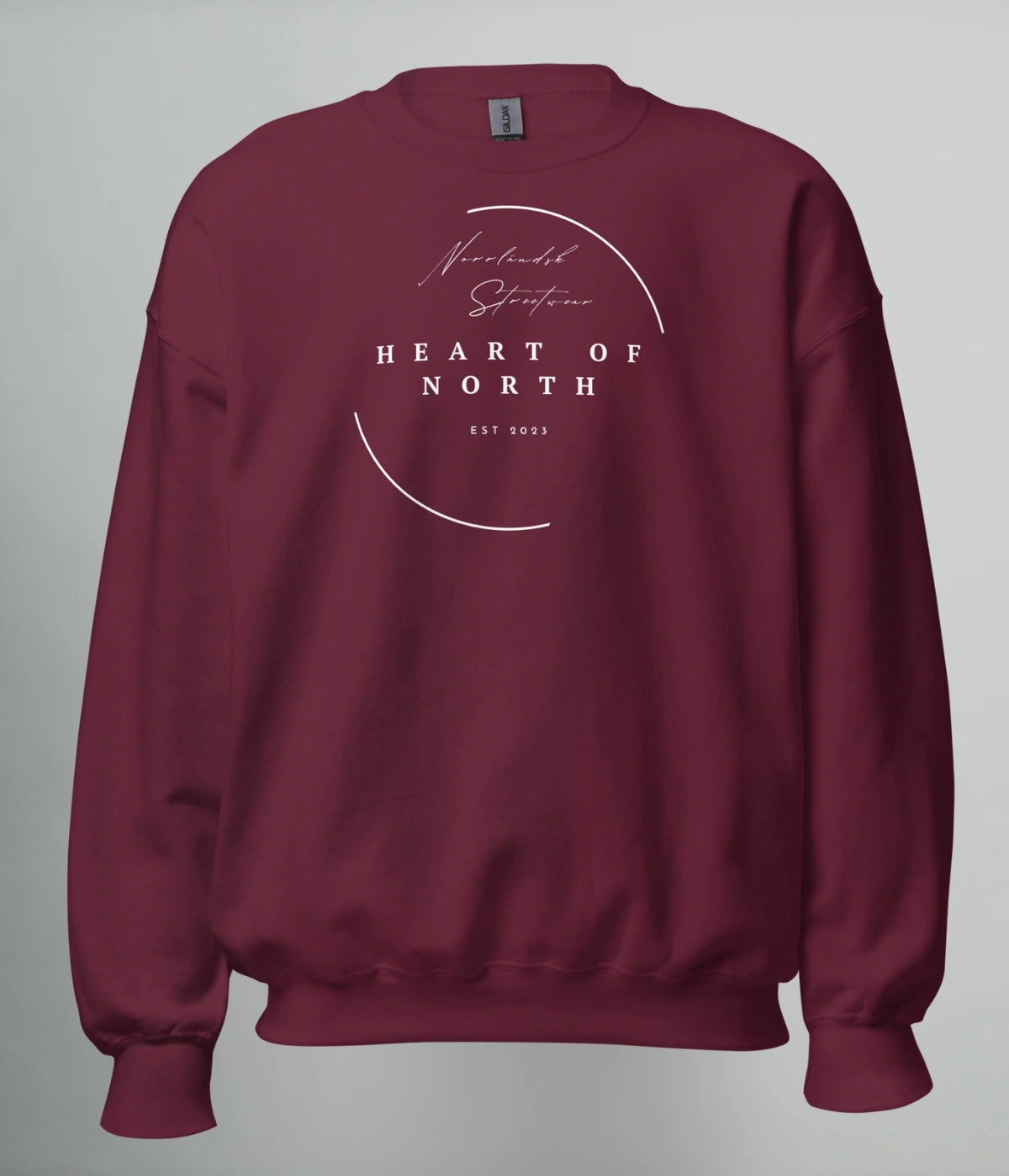Vinröd unisex sweatshirt med vit minimalistisk design och texten “Norrländsk Streetwear – Heart of North – EST 2023” tryckt framtill.