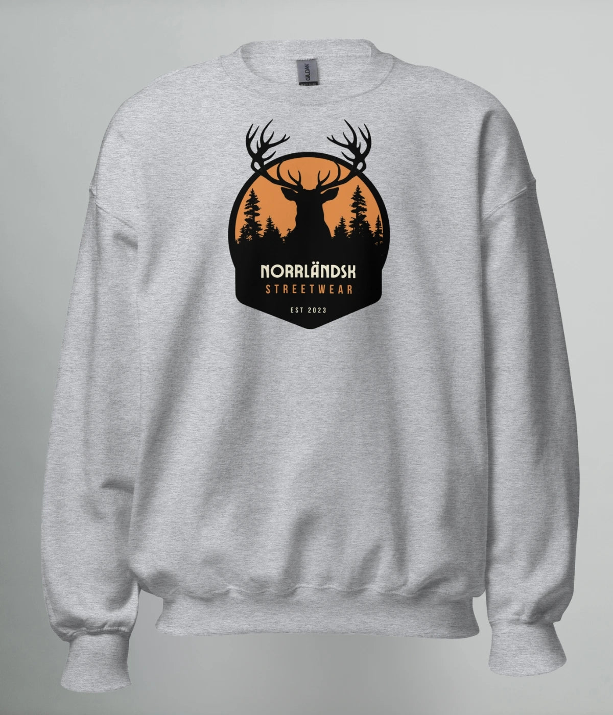 Grå unisex sweatshirt med silhuettmotiv av en hjort mot solnedgång och texten "Norrländsk Streetwear – Est 2023", tryckt på bröstet.